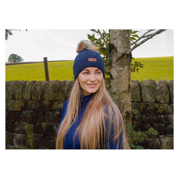 Lady wearing Cameo Cable Knit Bobble Hat in navy