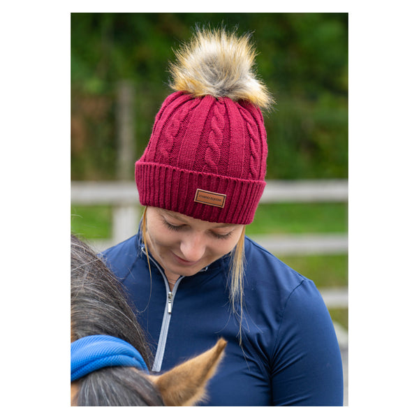 Close up of lady wearing Cameo Cable Knit Bobble Hat in plum