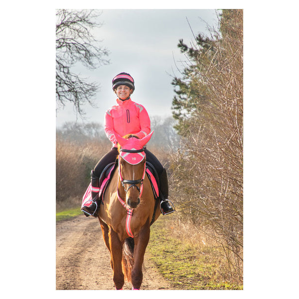 Rider wearing Reflector Jacket by Hy Equestrian in pink